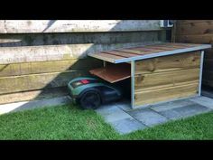 a lawn mower sitting next to a wooden shed