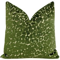 a green pillow with white spots on it