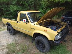 a yellow pick up truck with its hood open