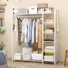 a white closet with clothes and other items hanging on the wall next to a bed