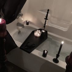 candles are sitting in the bathtub next to each other and on the edge of the tub