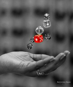 a hand holding a red dice in the air