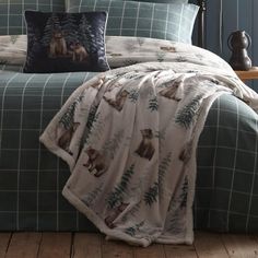 the comforter is made up with bears and pine trees on it, along with two pillows