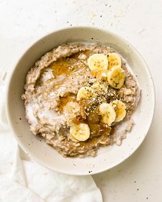 a bowl of oatmeal with bananas and chia seeds on the side