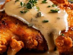 chicken covered in gravy and garnished with parmesan cheese on top