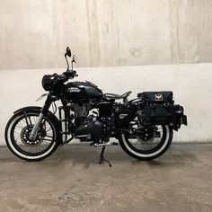 a black motorcycle parked next to a white wall