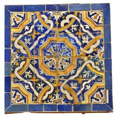 a blue and yellow tile with an intricate design on the bottom, surrounded by smaller tiles