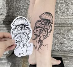 a person with a tattoo on their arm next to a sticker that has an image of a jellyfish