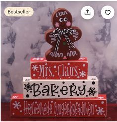 a gingerbread man is sitting on top of two red boxes that read mrs claus bakery