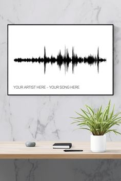 a black and white sound wave art print on a wall next to a potted plant