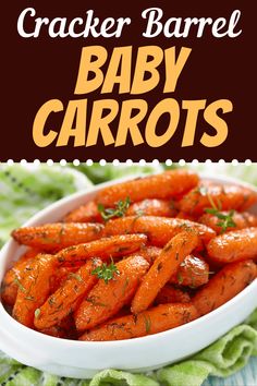 a white bowl filled with baby carrots on top of a green cloth