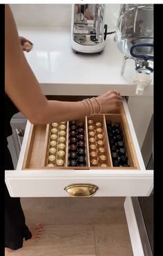 a drawer is open with chocolates in it and someone's feet on the counter