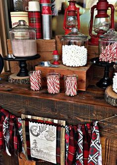 a table topped with lots of red and white candy canes on top of wooden boxes