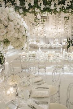 the tables are set with white flowers and candles