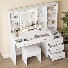 a white desk with drawers and a mirror on it's side, next to a potted plant