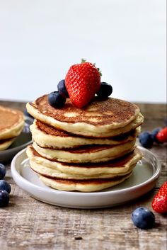 a stack of pancakes with fresh berries on top