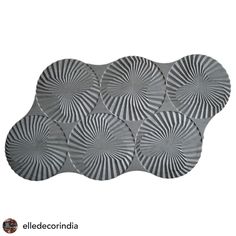 four circular metal plates with black and white designs on the sides, one is made out of