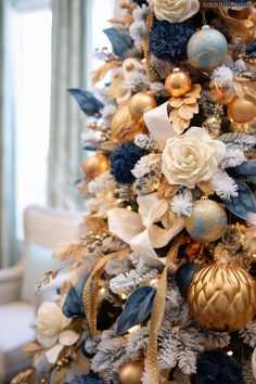 a decorated christmas tree with blue and gold ornaments