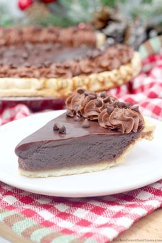 there is a piece of chocolate pie on the plate and another slice in the background