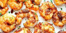 grilled shrimp on a white plate with parsley sprinkled around the edges