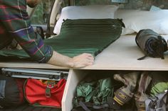 a man is unpacking his camping gear in the back of a truck bed