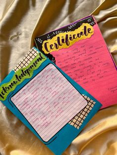 two notebooks sitting on top of a bed covered in yellow sheets and writing paper