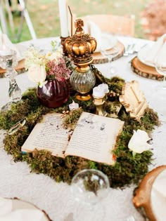 a table topped with an open book next to a candle