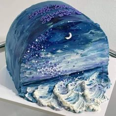 a blue cake with white frosting and purple icing on it's side