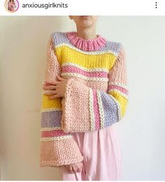 a woman is wearing a colorful sweater and pink pants