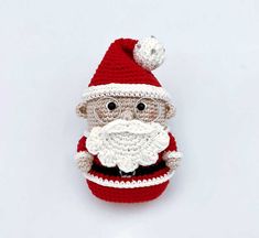 a crocheted santa clause hat with glasses and a beard on the top, sitting in front of a white background