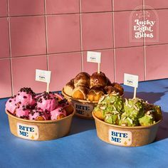 three baskets filled with different types of doughnuts on top of a blue table