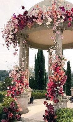 a gazebo covered in lots of pink and red flowers