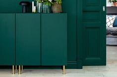 a living room with dark green walls and white rugs on the floor in front of an open door