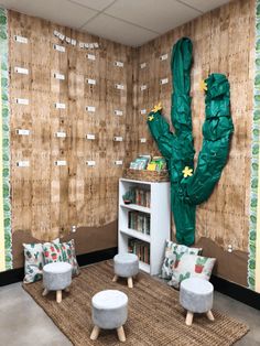 a living room with green cactus wallpaper and white furniture in front of a bookshelf