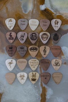 wooden guitar picks are arranged in the shape of a tree with names and symbols on them