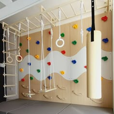 there is a climbing wall in the children's playroom with toys hanging from it