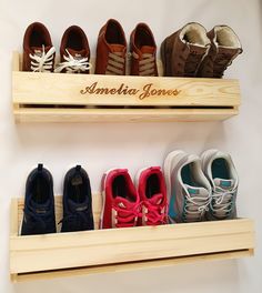 several pairs of shoes are lined up on wooden shelves with the name america jones written on them