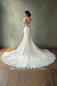 a woman in a white wedding dress standing on a wooden floor with her back to the camera