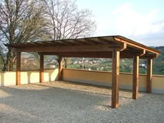 a wooden structure sitting on top of a gravel covered ground