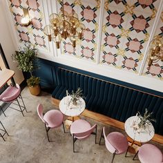 an overhead view of a restaurant with pink velvet chairs and gold chandeliers hanging from the ceiling