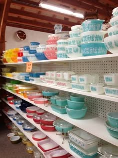 many bowls and plates are on shelves in a store