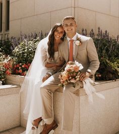 a bride and groom posing for a photo on the steps in front of a building