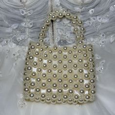 These gorgeous bridal bags are perfect for the modern bride who wants to make a statement. These bags, made of pearls of large and small sizes, are the most exclusive bridal bags that will leave an unforgettable impression. The entire bag is made of pearls, and thanks to its lining, you can safely keep your most valuable belongings with you. A must-have for every modern bride, these bridal bags add elegance and elegance to every bridal look. Show off your sophisticated sense of fashion and make Elegant Square Evening Bag For Wedding, Chic Top Handle Shoulder Bag For Wedding, Chic Square Clutch For Wedding, Elegant Top Handle Shoulder Bag For Wedding, Chic Pearl White Bag For Events, Handheld Shoulder Bag With Pearl Handle For Event, Rectangular Evening Bag With Pearl Handle, Glamorous Handheld Evening Bag With Pearl Handle, Glamorous Rectangular Shoulder Bag For Wedding