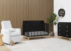 a black crib and white chair in a room