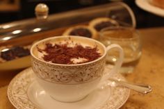 a cup filled with chocolate and cream on top of a saucer