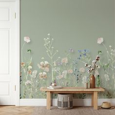 a living room with flowers painted on the wall and a wooden bench in front of it