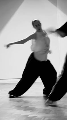 two people are dancing on the floor in black and white