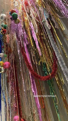 many streamers are hanging from the ceiling in front of a wall with ornaments on it