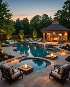 an outdoor swimming pool with fire pit and seating around it at dusk or sunset time