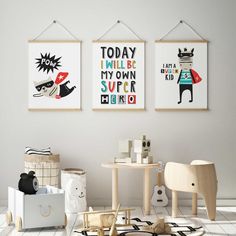 three children's art prints hang on the wall above a small table and chair